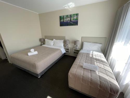 诺拉乔治巴斯汽车旅馆的一间卧室设有两张床和窗户。