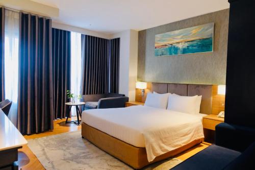 胡志明市Nicecy NganHa Hotel的配有一张床和一把椅子的酒店客房