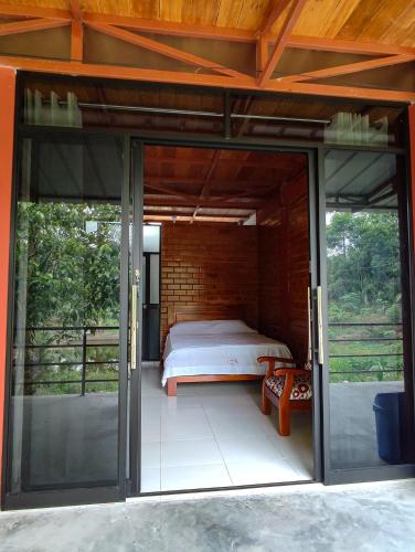 廷戈玛丽亚Cabañas Ecowasi的配有床和滑动玻璃门的房间
