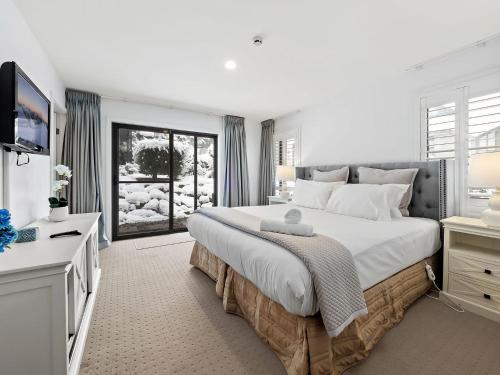 斯瑞德伯Snowbound 1的白色卧室设有一张大床和电视。