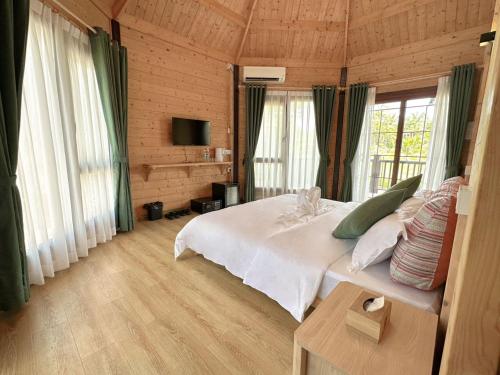 仙本那OPINE VILLAS/菠萝的海.度假别墅的一间设有床铺的卧室,位于带窗户的房间内