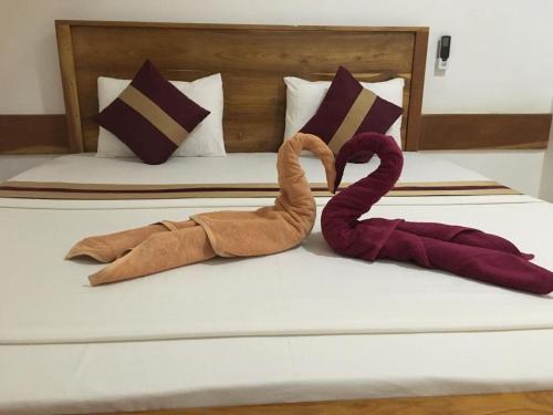 阿努拉德普勒Treasure House Tourist Rest的一张有两只天鹅绒的床,看起来像毛巾