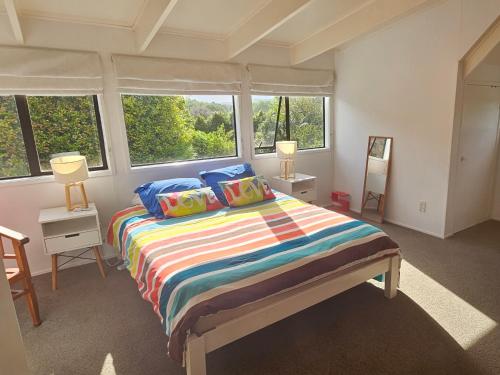 HaruruForest Waters Bungalow的一间卧室配有一张带彩色床单和窗户的床。