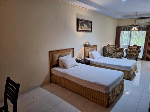 岩望Makati Pasuruan Hotel的酒店客房,配有两张床和椅子