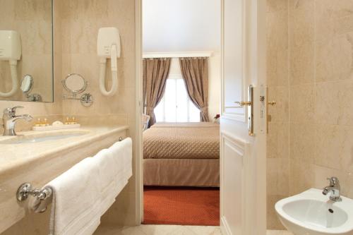 卢尔德现代大酒店的一间带水槽和床的浴室