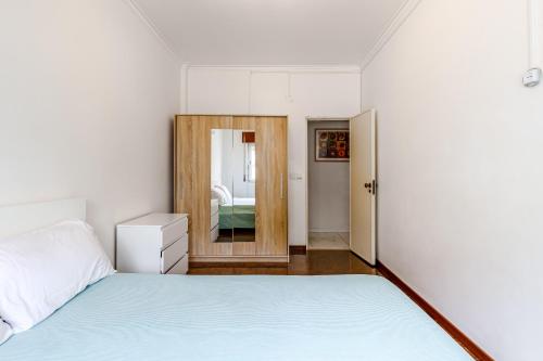 阿莫拉Moreira的一间卧室配有一张床和镜子
