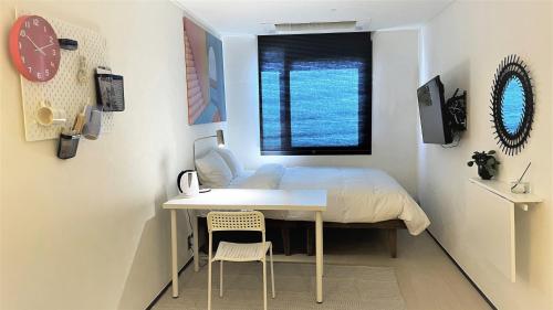 首尔Five hotel Jongno的一间卧室配有一张床、一张书桌和一个窗户。