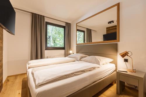 萨尔巴赫Saalbach Suites by ALPS RESORTS的一间卧室配有两张床和镜子