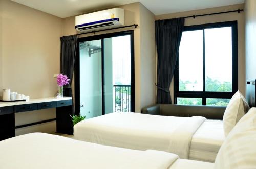 Bangkok NoiNORN Rimkhlong Bangkok นอนริมคลอง的酒店客房设有两张床和窗户。