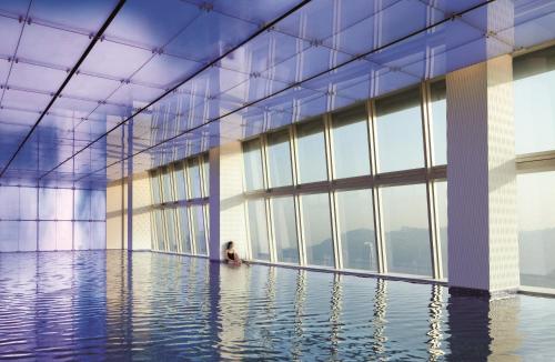 香港丽思卡尔顿酒店的坐在游泳池里,坐在有窗户的建筑物里的女人