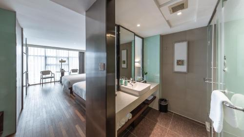 杭州杭州西湖武林Pagoda君亭设计酒店的浴室设有床、水槽和镜子