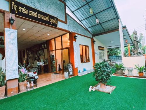 素可泰Phiphu Art and Gallery Boutique Sukhothai的前面有绿色地毯的房子