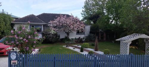 纳尔逊Morning Bloom Cottage Bed and Breakfast的花树屋前的蓝色围栏