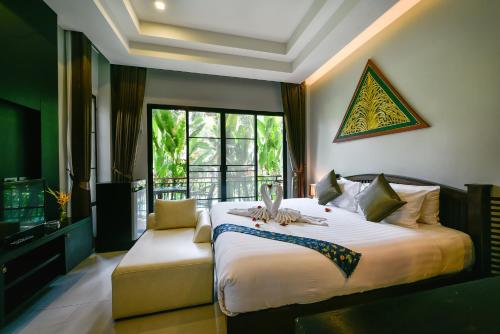查龙Coco Retreat Phuket Resort and Spa - SHA Plus的一间卧室设有一张大床和一个窗户。