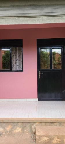 金贾Ronnie restate的粉红色的房子,设有黑色的门和窗户