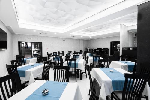 北马马亚-讷沃达里Hotel Javu的用餐室配有白色桌子和黑色椅子