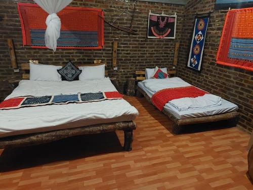 和平A La Homestay的带砖墙的客房内的两张单人床