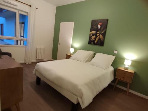 蒙蒂维利耶Zenao Appart'hôtels Montivilliers的卧室配有白色的床和绿色的墙壁