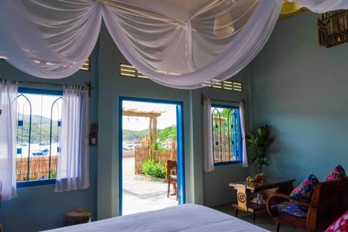 永熙La Mer - Vĩnh Hy bay - beachfront villa CHÀI的一间卧室配有床和两个带窗帘的窗户