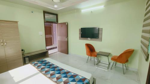 珀勒德布尔HOTEL AMAR PALACE BHARATPUR的一间带床和两把椅子的房间以及一台电视