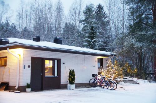罗瓦涅米The Blueberry Inn的一辆自行车停在房子外面雪地里的房子