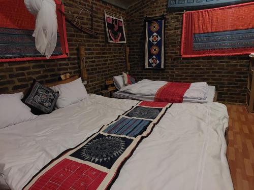 和平A La Homestay的带砖墙的客房内的两张单人床
