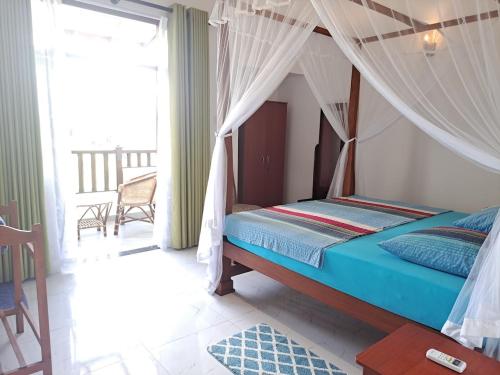韦利格默Villa 76的一间卧室配有一张带天蓬的床和一个阳台