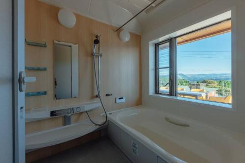 南阿苏村asoha的带浴缸、水槽和镜子的浴室