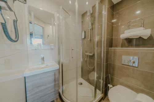 萨兰KYRIAD DIRECT ORLEANS NORD - Cap Saran的带淋浴、卫生间和盥洗盆的浴室