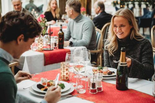 SäröSäröhus Hotel, Conference & Spa的一群坐在餐桌上吃食物的人