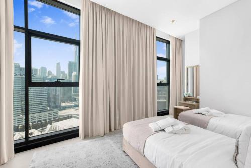 迪拜Meerak Homes - Glamorous 2 bed Apartment with Panoramic Views - Business Bay with free Wifi, Parking, Gym and Pool的酒店客房设有两张床和大窗户。