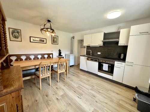 Pinsdorf乡村度假屋 - 蒙登涅的厨房配有白色橱柜和木桌
