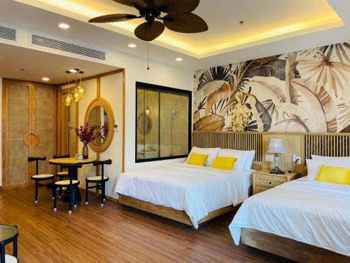 归仁Hanie Apartment - FLC Sea Tower Quy Nhon的酒店客房带两张床、一张桌子和一间餐厅