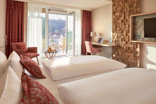 斯塔茨巴德·布鲁克瑙多灵特度假村&巴特布吕肯瑙浴场的酒店客房设有两张床和一个阳台。