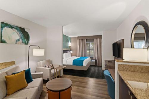 维洛海滩Comfort Suites Vero Beach I-95的酒店客房设有一张特大号床和一间客厅。