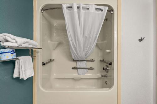 威尔明顿睡眠旅馆的浴室内带白色窗帘的淋浴