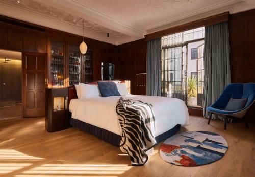 悉尼悉尼QT精品酒店的一间卧室设有一张大床和一个大窗户