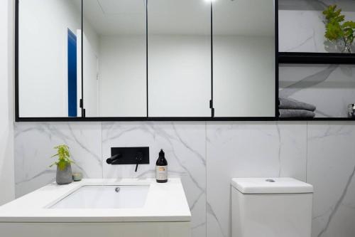 墨尔本Luxury Living, Richmond的白色的浴室设有水槽和卫生间。