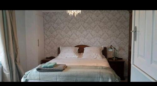 GreasbroughWingfield House 3 Bed的一间卧室配有带枕头和吊灯的床
