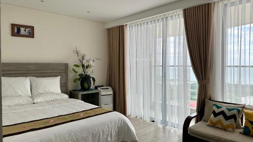 绥和市Apec Mandala Phú Yên View Biển的一间卧室设有一张床和一个大窗户