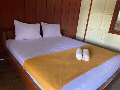 Ban DonsômSouksanh Guesthouse的床上有两块白色拖鞋