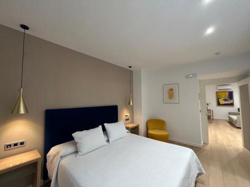 卢塞纳卢塞纳圣多明各酒店的一间卧室配有一张白色的床和蓝色床头板