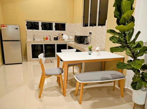 巴佐Homestay Rumah Tengok Jelawat Bachok的厨房配有桌子、两把椅子和冰箱
