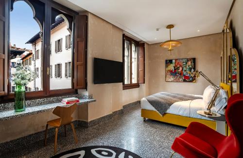佛罗伦萨Hotel Calimala的一间卧室设有一张床、一台电视和一个窗口。