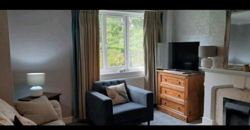 GreasbroughWingfield House 3 Bed的客厅配有电视、椅子和壁炉