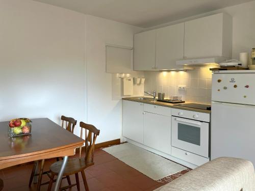 维拉诺瓦-德法马利Casa do Tanque的一间厨房,配有白色家电和桌椅