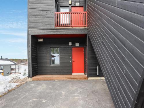 HyrynsalmiHoliday Home Skivillas 47 ukkohalla - a1 by Interhome的黑色的房子,设有红色的门和阳台