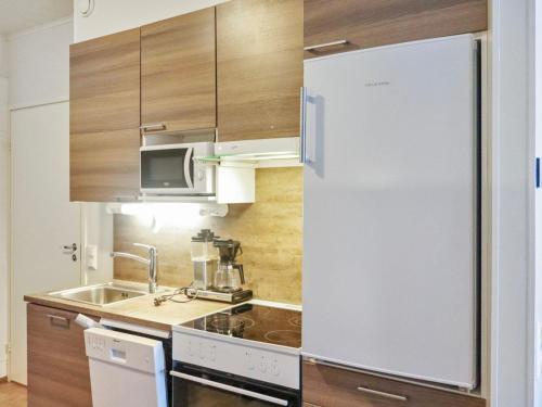 HyrynsalmiHoliday Home Skivillas 47 ukkohalla - a3 by Interhome的厨房配有白色冰箱和水槽