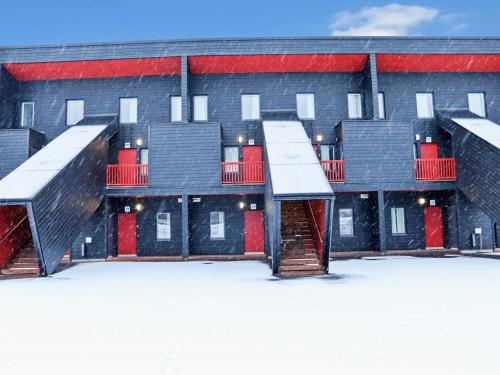 HyrynsalmiHoliday Home Skivillas 47 ukkohalla - a3 by Interhome的雪中一排红色门的建筑
