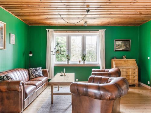 LammhultHoliday Home Älmegården - SND127 by Interhome的客厅设有绿色的墙壁和皮革家具。